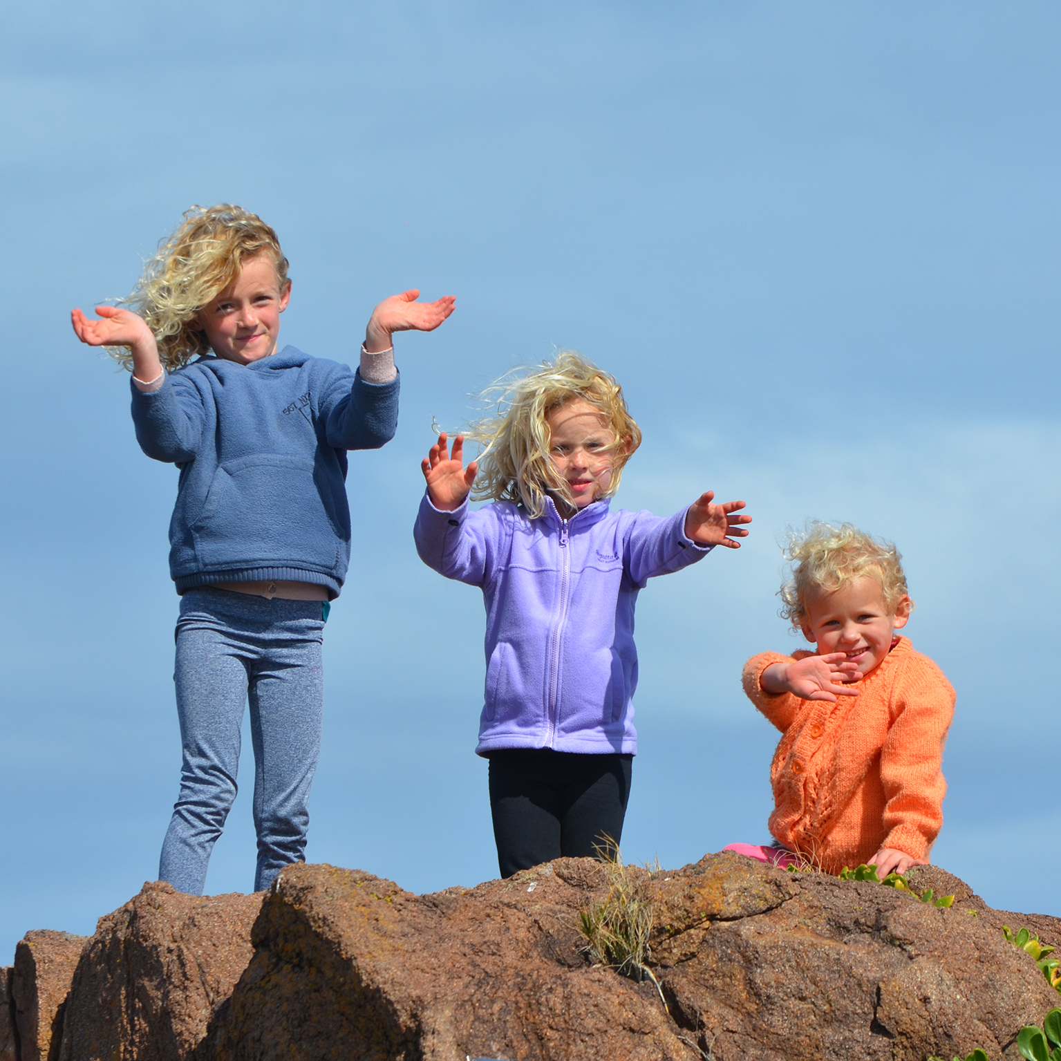 Canva - 3 Kids Standing on Rock